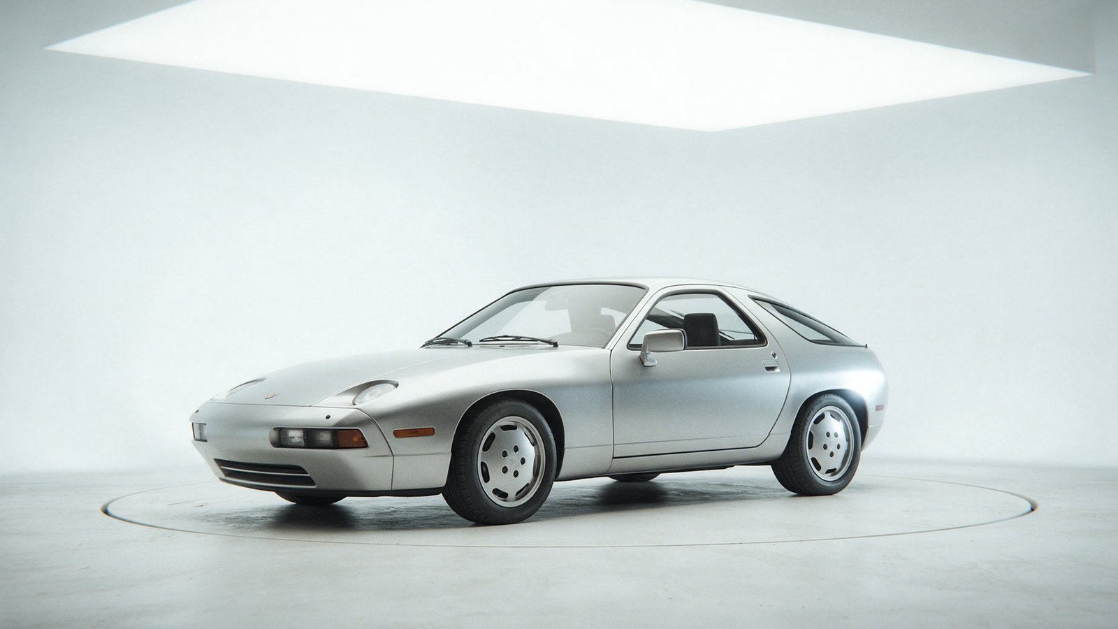 Silver stock sports coupe in a bright automotive studio